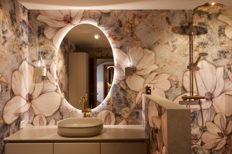 Die Tapete im Bad von Designers Guild zeigt Magnolienblüten, deren Pastelltöne zu den Armaturen in Roségold passen.