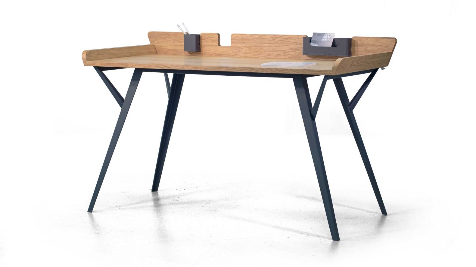Elegant und zeitlos: Der Schreibtisch «Diag» von Marek Blazucki kann sowohl an der Wand befestigt als auch frei im Raum aufgestellt werden. Seine besondere Form verdankt er seiner ausgeklügelten Funktionalität: Erhöhte Ränder verhindern das Herunterfallen von Gegenständen, ausserdem kann man in den Aussparungen an der hinteren Kante optionale Accessoires wie Behältnisse aus Leder für kleinere Utensilien anbringen. Dank seines eleganten Designs muss sich der Schreibtisch nicht im Arbeitszimmer verstecken, sondern kann auch im Wohnzimmer stehen. BOZZETTIDESIGN.COM