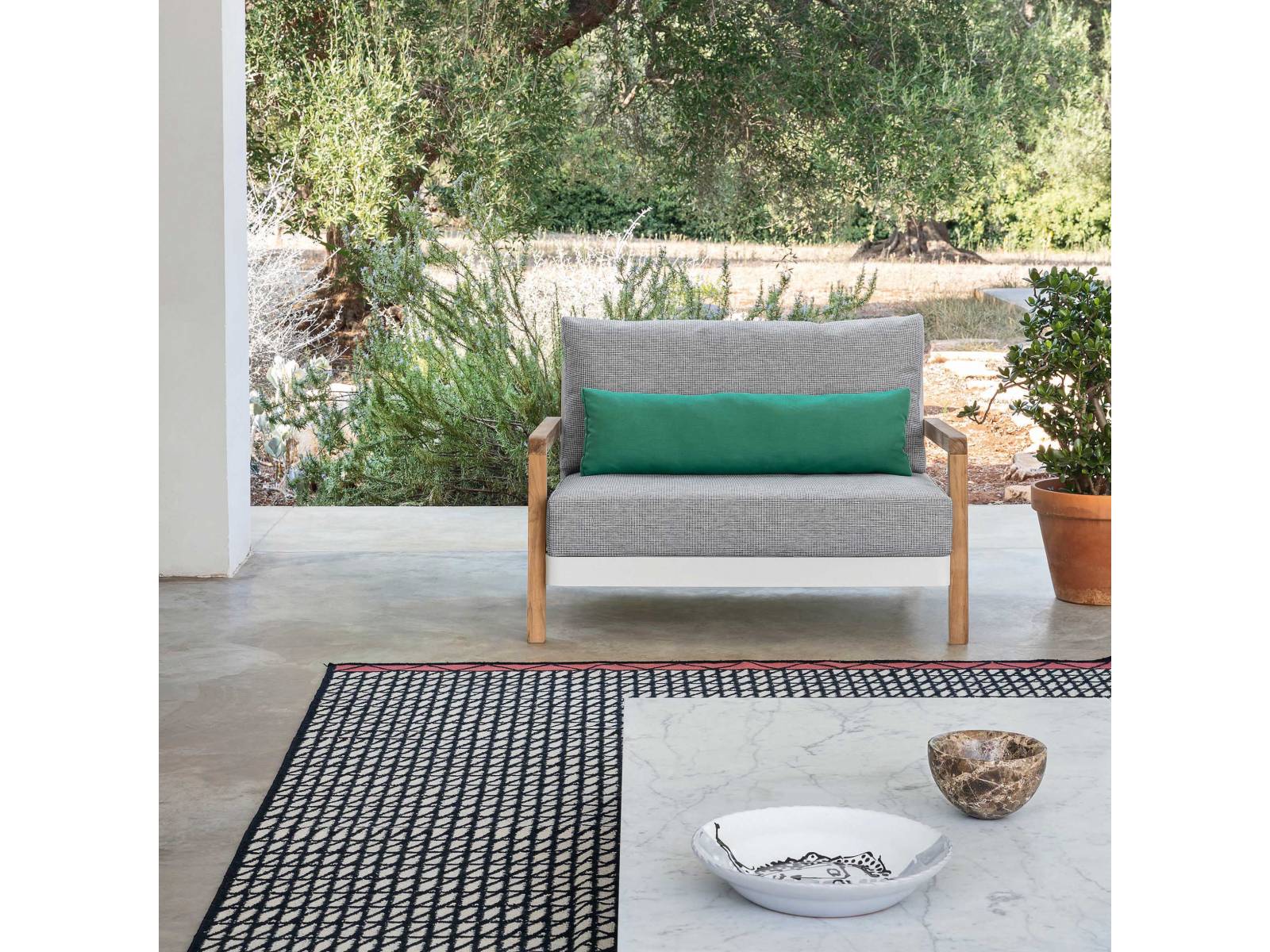 Die richtige Balance hat Paola Navone für ihre neueste Outdoor-Kollektion gesucht und gefunden. Für Win kombiniert die Italienerin einen weissen Aluminiumrahmen mit Armlehnen aus Naturteak. Streng gepolsterte Sitz- und Lehnenkissen unterstreichen das auffällig  reduzierte Design, welches als Sessel oder Sofa zu haben ist. GERVASONI.