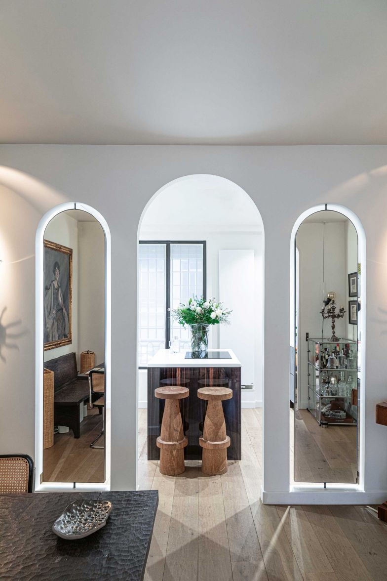 Die Wandöffnungen vom Esszimmer in die Küche sind speziell. Der Segmentbogen findet sich auch an anderer Stelle des Appartements. In der Küche selbst kombinieren die Interior Designer wertvolles, lackiertes Makassar-Ebenholz mit emailliertem Lavastein und natürlichem Eichenholz.
