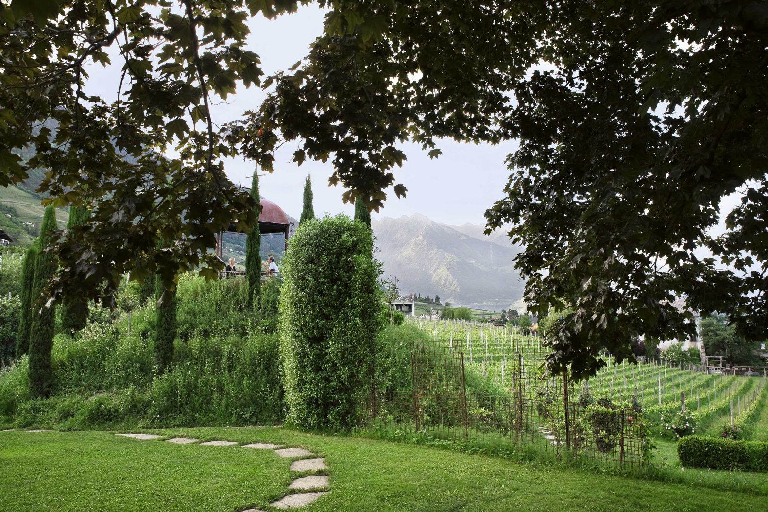 Franz von Pfeil erbte ein kleines Weingut mit dem historischen Ansitz Kränzelhof. Seit vielen Jahren werden hier exquisite Südtiroler Weine produziert. Eine Reise durch englische Gärten faszinierte ihn und seine Frau Stephanie so sehr, dass beide das grosse Terrain in eine einzigartige Gartenlandschaft verwandeln wollten. Die sieben Gärten sind ein lebendiges Kunstwerk und die Bühne für wechselnde Ausstellungen nationaler und internationaler KünstlerInnen – eine Garden Art Gallery. Die über 20 000 m2 grosse Installation im Grünen ist ein Ort zum Entspannen, um Kraft zu tanken, zum Staunen und Geniessen. KRAENZELHOF.IT