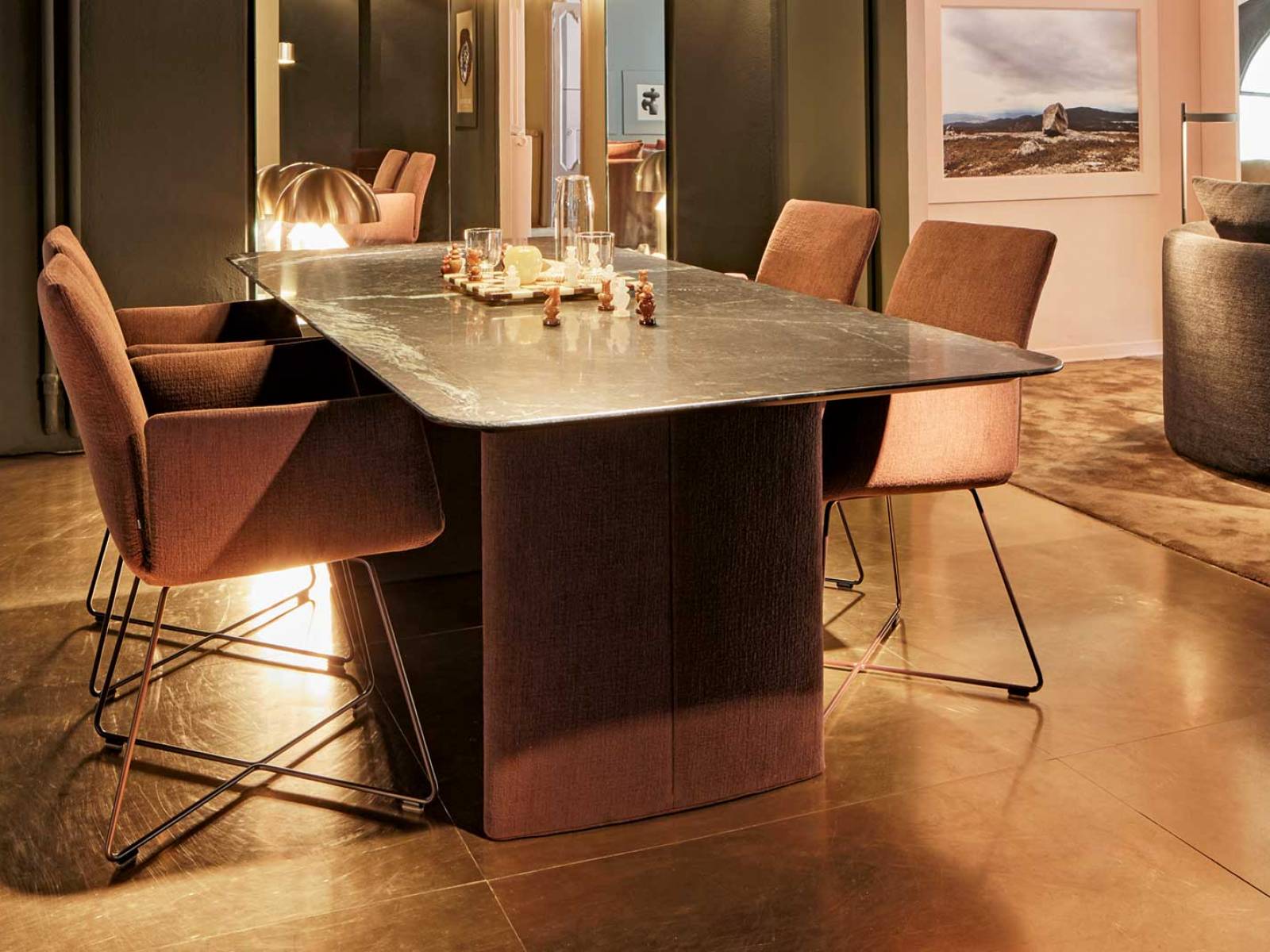 Die elliptisch gepolsterten Wangen des Esstisches «Ipa» bilden eine elegante Brücke zu den Stühlen im gleichen Bezugsstoff. So entsteht eine harmonische Wohnlichkeit, die auf dem raffinierten Konzept des Designteams Kräling-Lübke beruht. Foto Laura Thiesbrummel. COR.